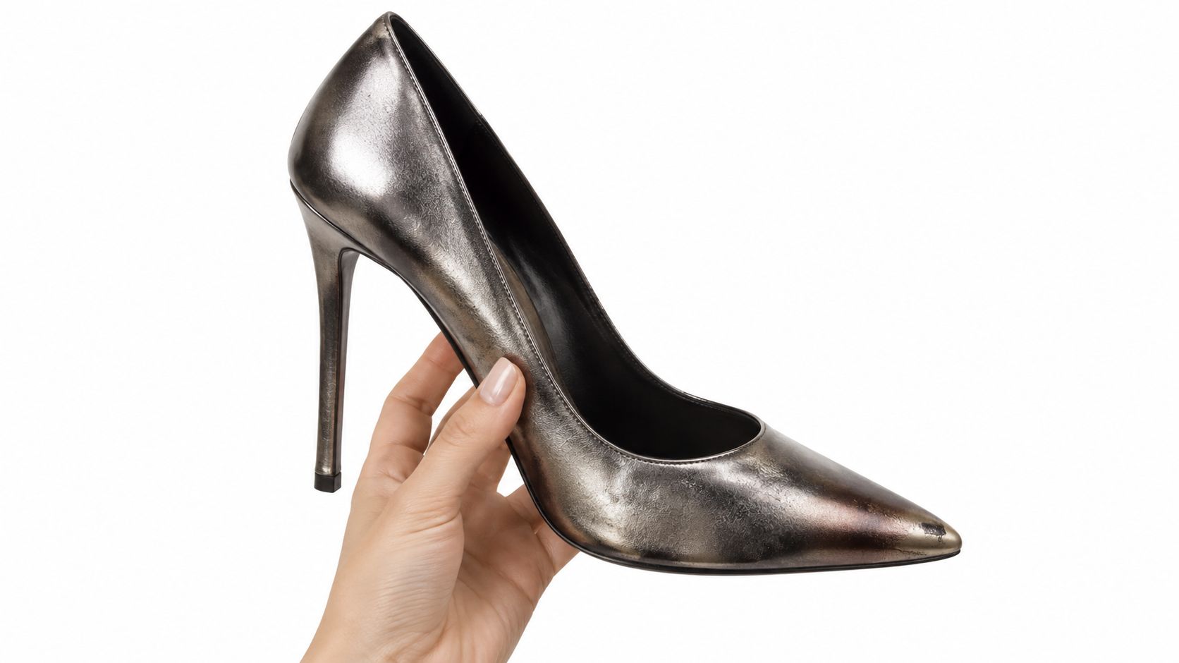 A hand holding a stylish metallic dark silver stiletto high heel shoe against a white background.